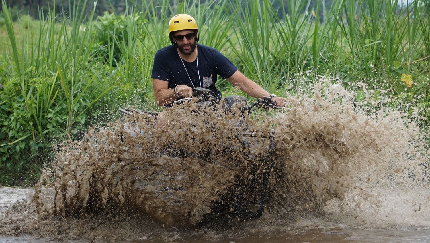 Tourists riding single and tandem quad bikes on the Bali ATV Ride and Ubud Tour track