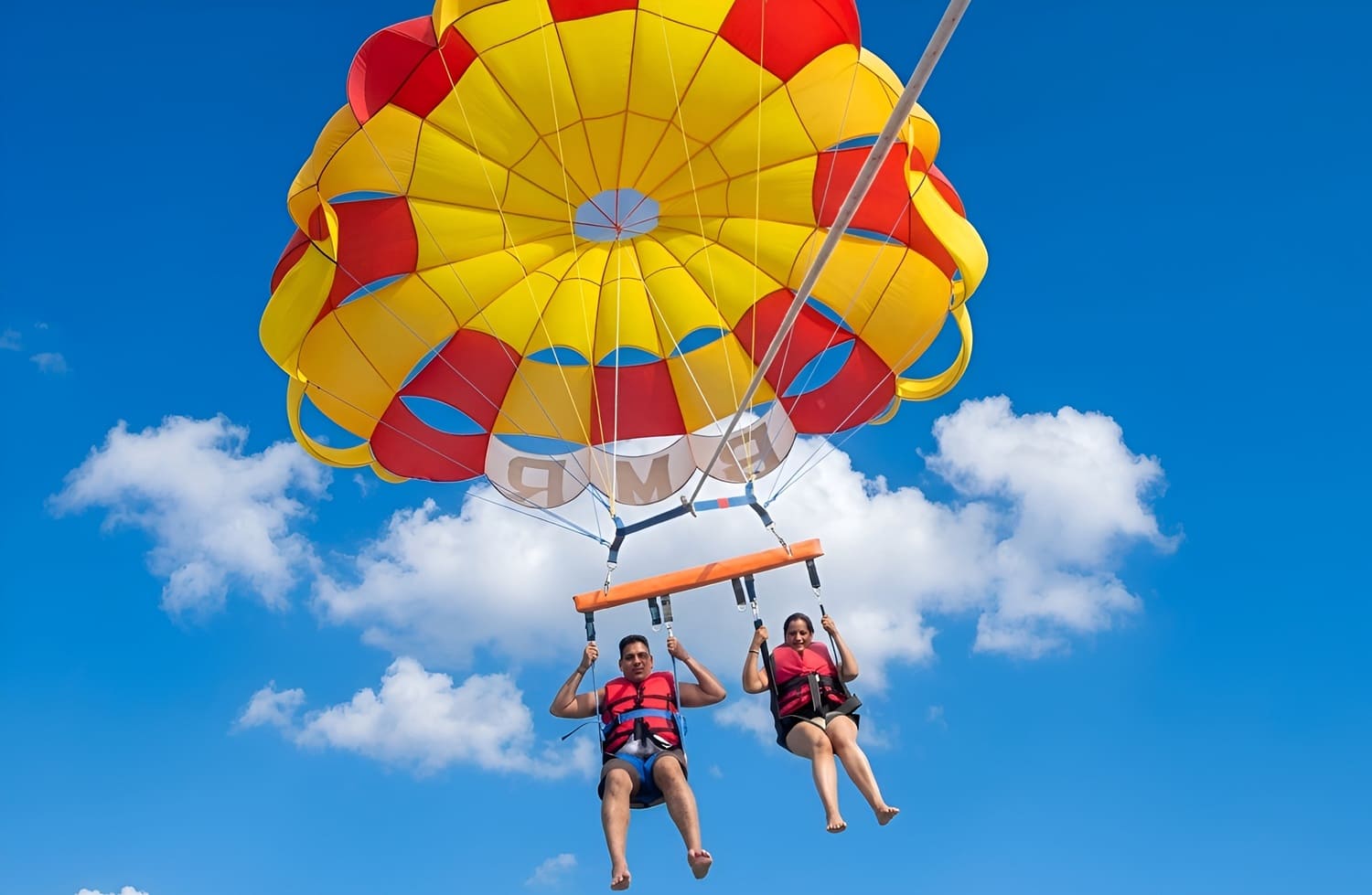 Couple doing Parasailing Adventure during Water Sports Activity in Tanjung Benoa Beach